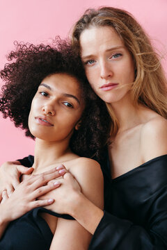 Friends Embrace Against a Bright Pink Background