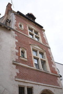 Historic French facade featuring traditional red brick and stone masonry in Orleans