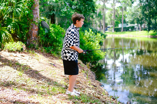  fishing by a calm pond in a lush green park.