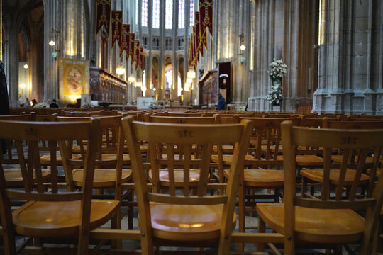 Wooden chairs arranged in a cathedral interior for religious service in Orleans