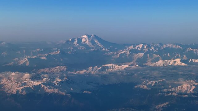 Aerial view of Mount Elbrus and snowy Caucasus mountain range at sunrise