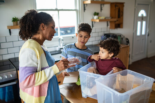 Mother and children recycling plastics at home