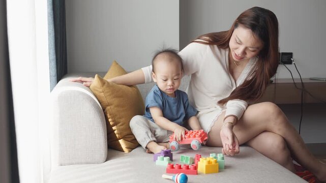 A warm and joyful moment between a mother and her child as they engage in playtime on a cozy sofa, fostering bonding and creativity.