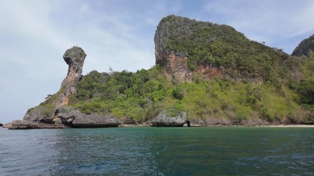 Koh Gai , Chicken Island in Krabi Thailand Lush green cliffs rise majestically above calm waters, creating a serene coastal landscape perfect for nature enthusiasts and travelers seeking tranquility