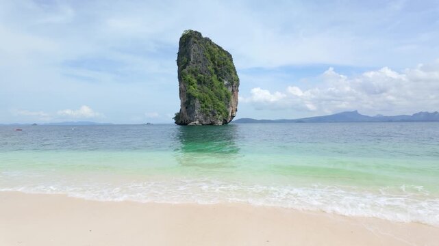 Ko Poda in Krabi Thailand, stunning seascape featuring towering limestone cliff amidst gentle waves sandy beach and blue sea, showcasing the beauty nature tranquility