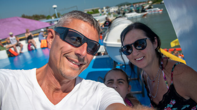 Parents and children enjoying a fun ferry ride and taking a selfie together