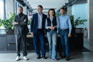 Fototapeta premium Happy business people team standing together in office. Smiling professional employees company staff with older executive leader