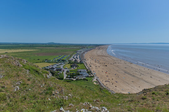 A scenic aerial view of Brean Beach, England, featuring a long, sandy coastline, blue sea, and a village - on top of Brean Down - Burnham-on-Sea - UK