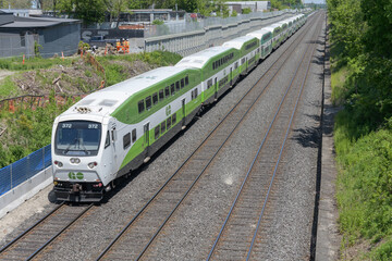 Fototapeta premium Metrolinx Lakeshore East Rail Corridor (Kingston Subdivision) with Go Train heading westbound to Union Station - view over bridge on Birchmount Rd, Scarborough