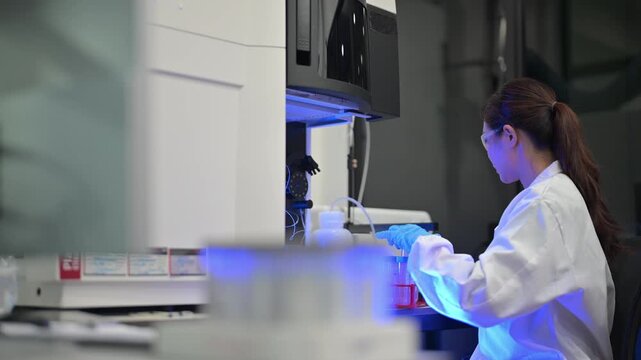 Scientist in protective gear working with advanced laboratory equipment and blue lighting
