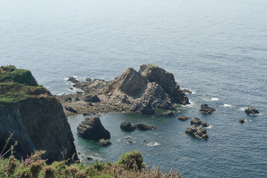 High angle view of rocky islet and dramatic cliffs in the blue ocean