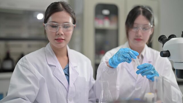 Laboratory work with samples and microscope in a research lab with two scientists