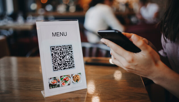 Customer scanning a QR code menu with a smartphone in a restaurant, showcasing digital dining, contactless ordering, and modern hospitality technology.