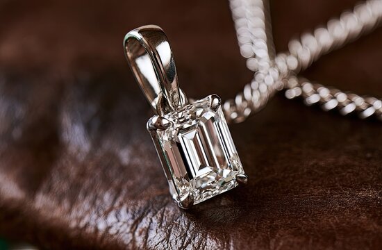 Elegant emerald-cut diamond pendant, silver chain, rich brown backdrop