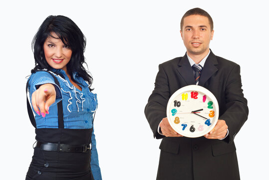 Woman points accusingly at man holding a clock