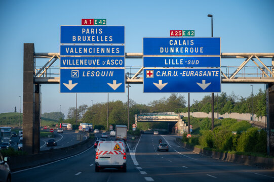 View of a French and European autoroute with overhead directional signs pointing to major cities like Paris, Bordeaux, Lille, Calais, showing lanes, traffic and motorway infrastructure, road signes
