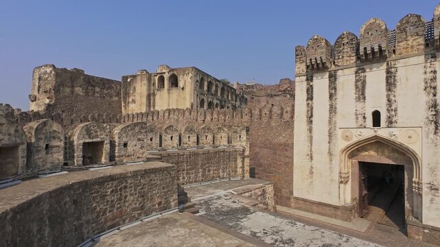 Panoramic view of ancient Golconda Fort architecture in Hyderabad, India. Historic Islamic citadel and medieval defensive complex in Telangana under clear blue sky.