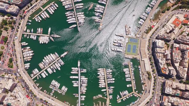Beautiful aerial top-down view flying over marina zeas, pasalimani harbor, in piraeus, greece, showcasing luxury yachts, sailboats, and the surrounding urban cityscape on a sunny day