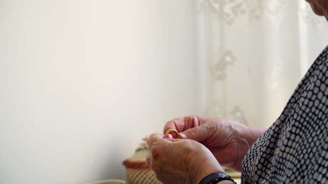 An elderly woman puts some gold rings in the jewelry box