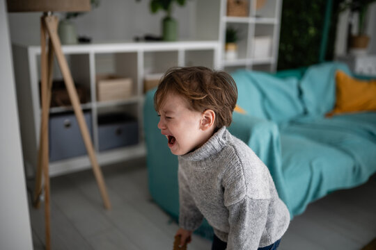 Toddler having tantrum crying loudly upset indoors