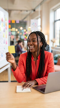 happy african woman brainstorming with sticky notes in modern office space