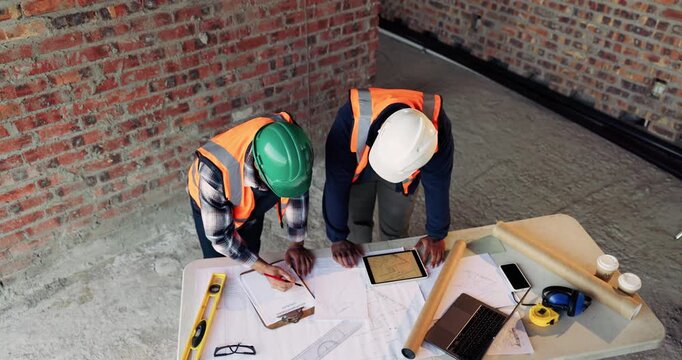 Speaking, team or architect with document at construction site, property guidelines or remodel project. Review, above or people with clipboard for building codes info, writing or planning renovation