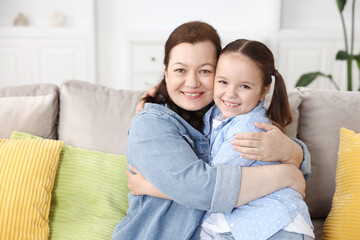 Obraz premium Grandmother and her granddaughter on sofa at home, space for text
