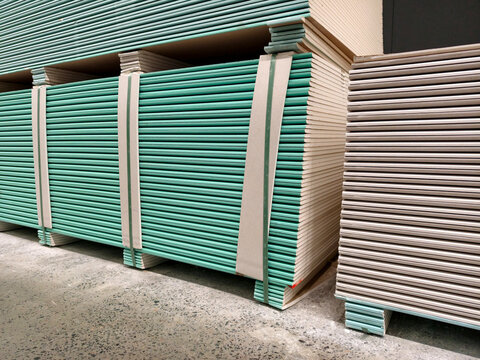 Rows of drywall sheets stacked for easy access in a construction material warehouse