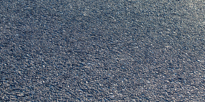 Fresh dark grey asphalt road surface texture as textured panoramic industrial abstract background