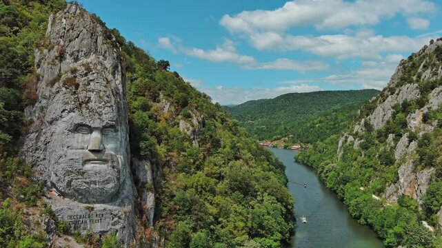Aerial view of stone carved statue portrait of ancient dacian king Decebal. Sculpture located on shore of Danube River, Romania, 4k