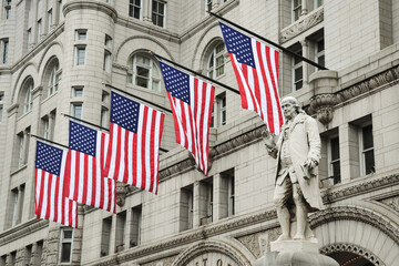 Naklejka premium Statue of Benjamin Franklin with American Flags in front of an Historic Building