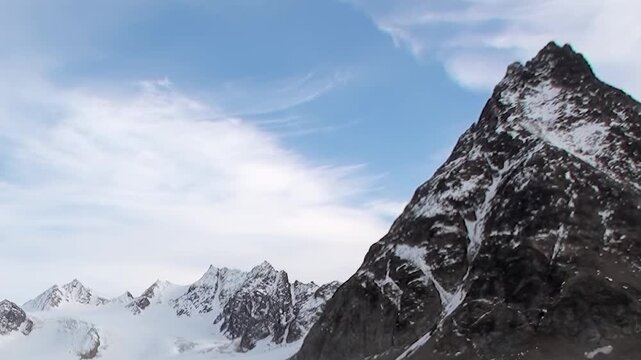 An expansive view of an Arctic glacier and its formidable snow-capped mountains.
