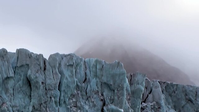 A colossal Arctic glacier presents its formidable ice wall, a testament to nature's raw power.