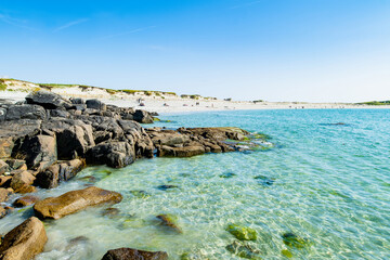 Fototapeta premium Rocky shoreline and turquoise water at Dogs Bay near Roundstone, Connemara, County Galway. Scenic white sand beach on the Wild Atlantic Way beside Gurteen Bay, Ireland