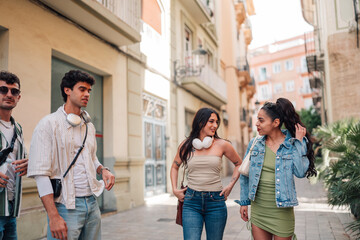 Fototapeta premium Diverse friends walking, talking, and enjoying an urban city trip together during summer vacation