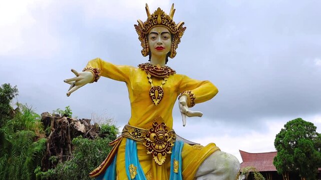 Golden traditional Balinese dancer statue in ornate ceremonial costume, showcasing the rich cultural heritage of Bali, Indonesia