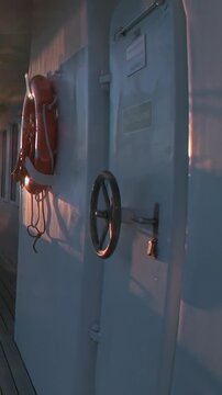 A lifebuoy hangs on a sturdy vessel's bulkhead during a serene Arctic golden hour.