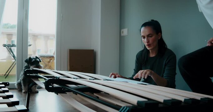 Confident woman assembling flat pack bed frame at home