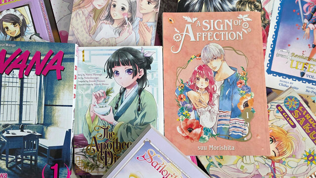 stacks of josei and shojo manga books piled on top of each other including Sign of Affection and Apothecary Diaries, May 28, 2026, Schaumburg IL