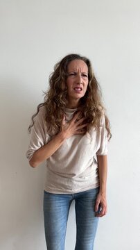 Mujer blanca con dolor en el pecho sobre fondo blanco