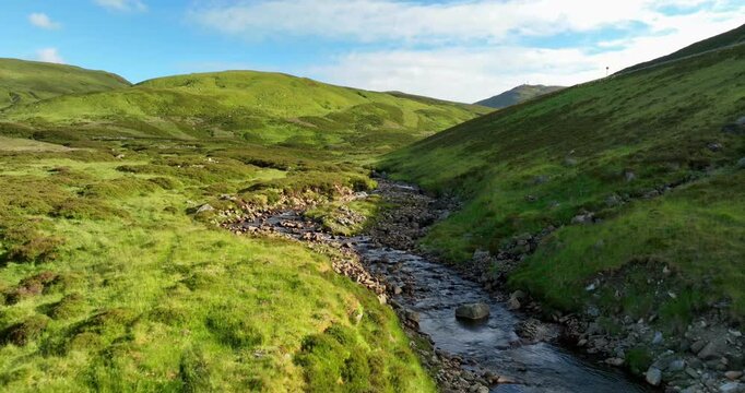 Low aerial footage along Scotish highland stream 