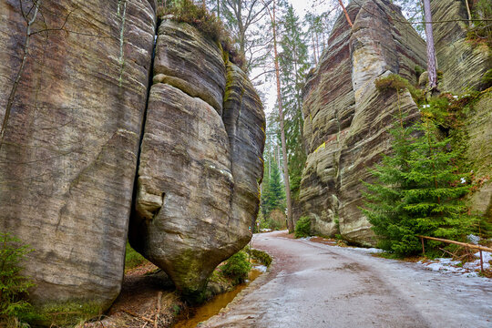 Narrow pathway through majestic rock formations in winter forest
