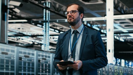 Upgrading systems, tablet and software developer in data center using augmented reality to install server racks, Monitoring server hub, VFX overlay and employee using device automation app, camera B. © DC Studio