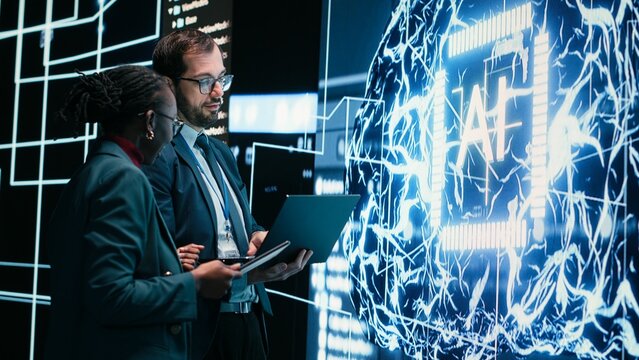 Autonomy concept, AI machine learning and engineering team looking at self writing code on screen, artificial intelligence and teamworking colleagues reviewing self sustaining AI model.