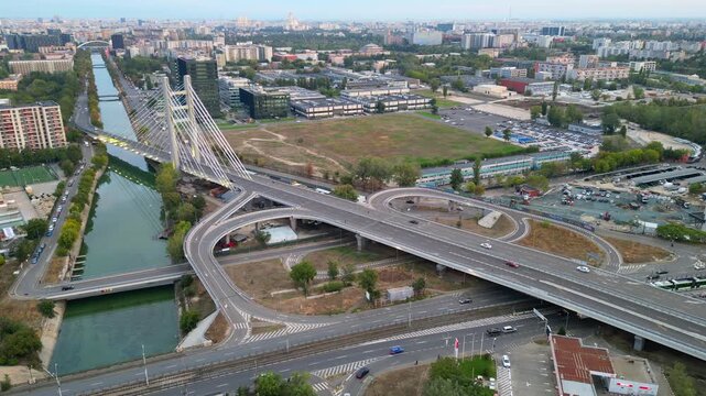 High angle twilight view of the modern Ciurel cable-stayed bridge in Bucharest, Romania. Scenic urban infrastructure with glowing traffic lights at sunset.