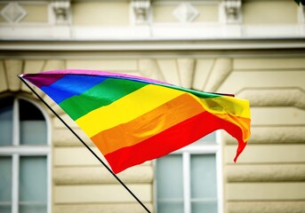 Vibrant rainbow lgbtq+ flag waving outdoors in urban setting during pride parade in Klagenfurt Austria © HelgaQ