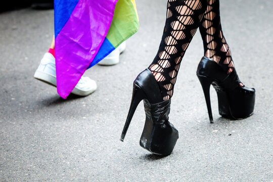 Colorful legs with fishnet leggings and high heels on asphalt street during pride parade in Klagenfurt Austria