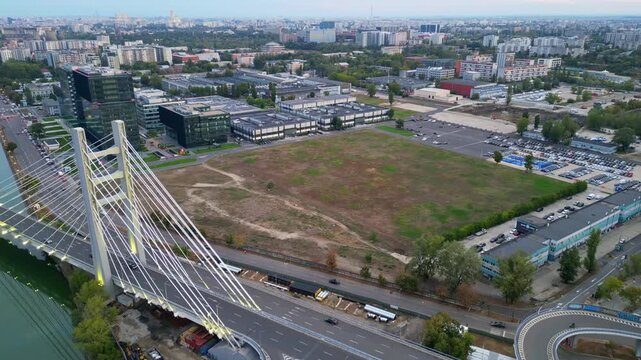High angle twilight view of the modern Ciurel cable-stayed bridge in Bucharest, Romania. Scenic urban infrastructure with glowing traffic lights at sunset.
