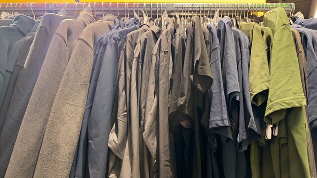 Casual clothes hanging on rails in clothing store, apparel assortment on hangers in shop