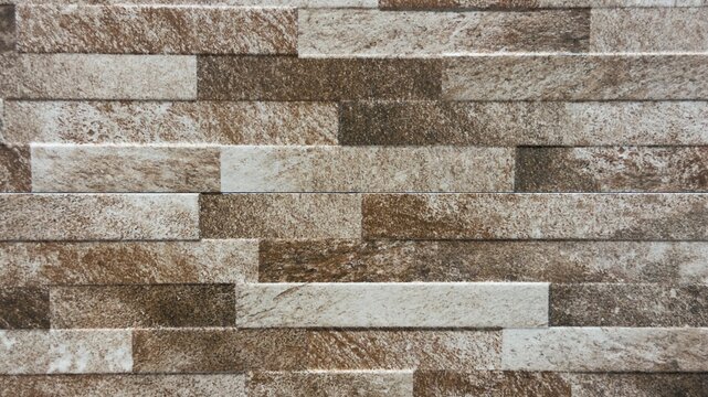 Natural stone wall texture background with horizontal quartz cladding bricks close up.